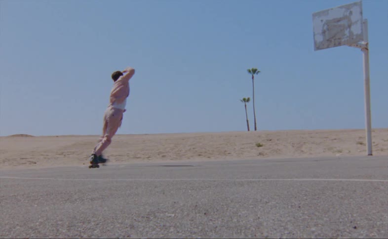 A man dances on roller skates in a parking lot