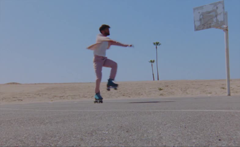 A man does a pirouette in roller skates on an outdoor basketball court during the day