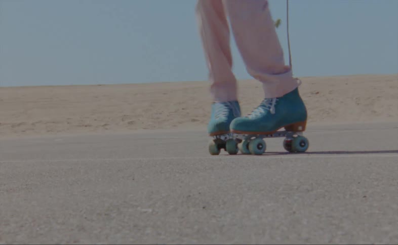 A man dances in roller skates in a parking lot