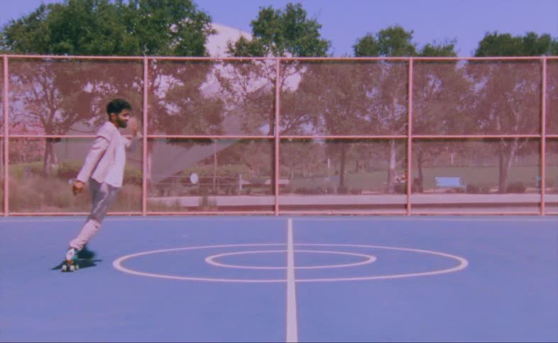 A man dances on a basketball court in roller skates