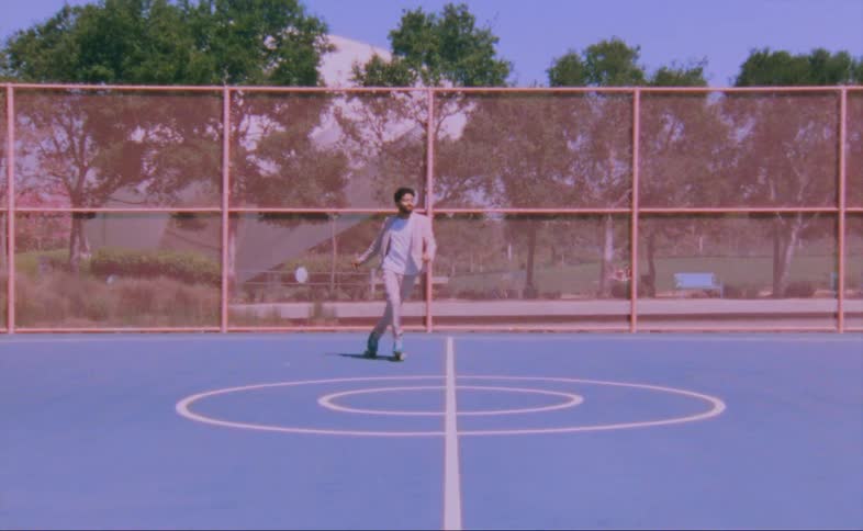 Man on turquois roller skates moves over a hard surface in the court