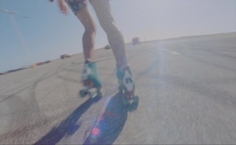 Person dances on roller skates in parking lot