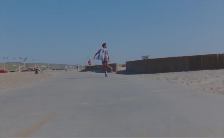 A man dances as he roller skates on the boardwalk