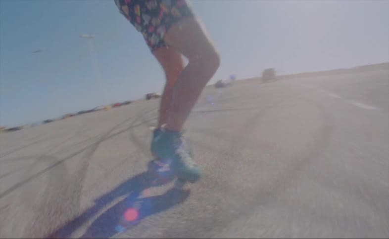 A person is skating outdoors in a parking lot