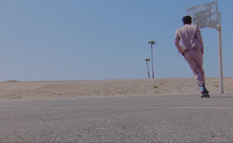 A man is skating and dancing on an empty street