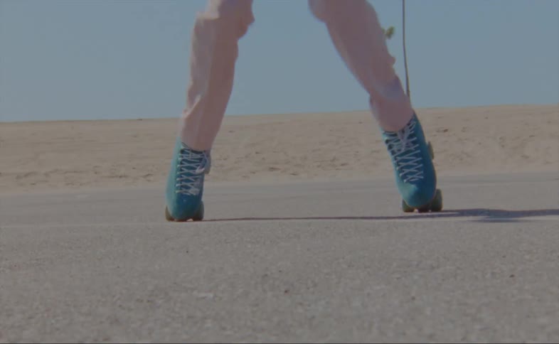 A person is doing tricks on roller skates near a beach