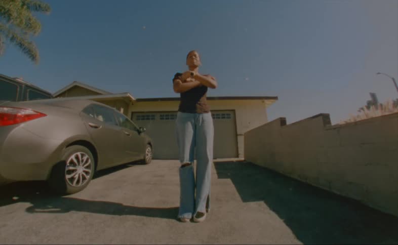 A woman is smiling and standing by her parked vehicle
