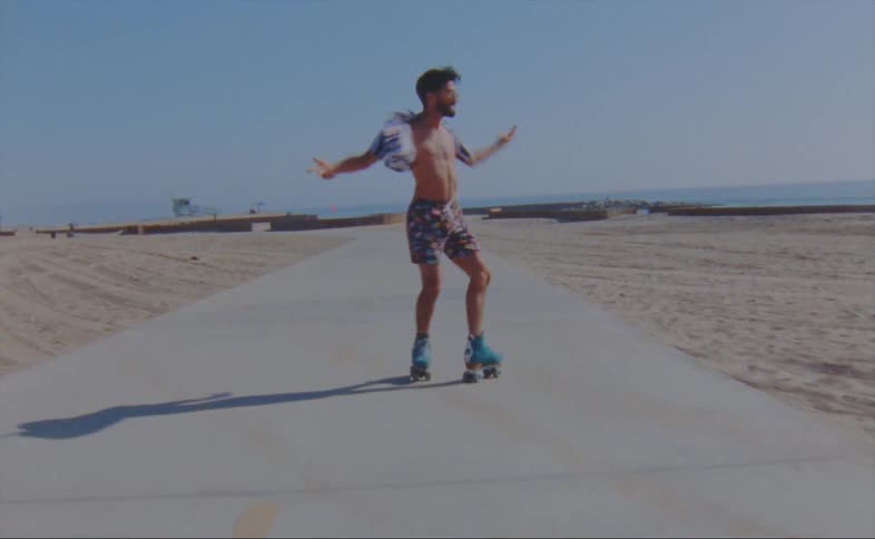 A man is skating and dancing outdoors in a desert area