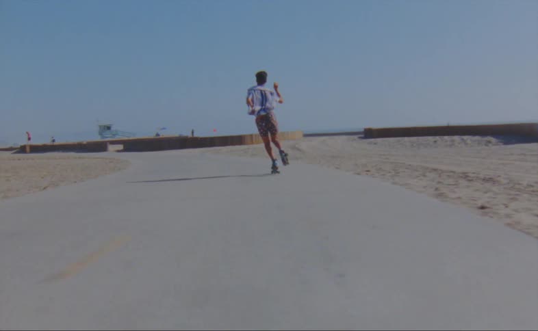 Man roller skating on the boardwalk at the beach