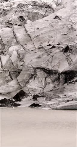 Dirty snow next to flowing water in nature