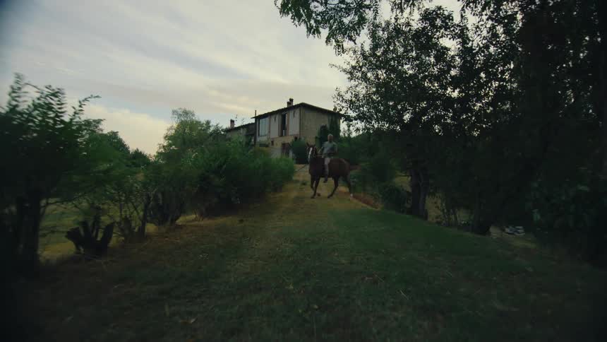 A man rides a horse in a rural area
