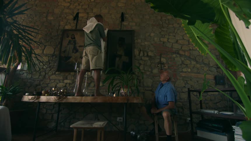 A man uncovers a painting on the wall