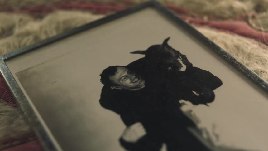 Silver framed black and white photo of man and dog