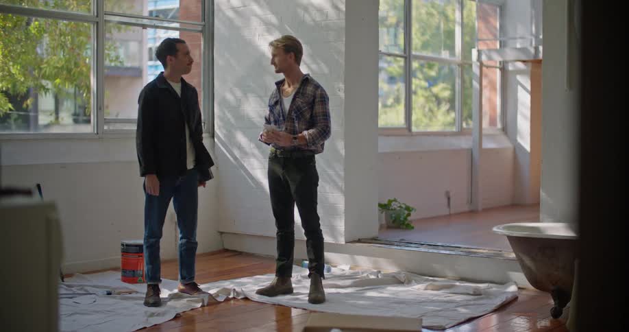 Two men remodeling an apartment in the city shake hands