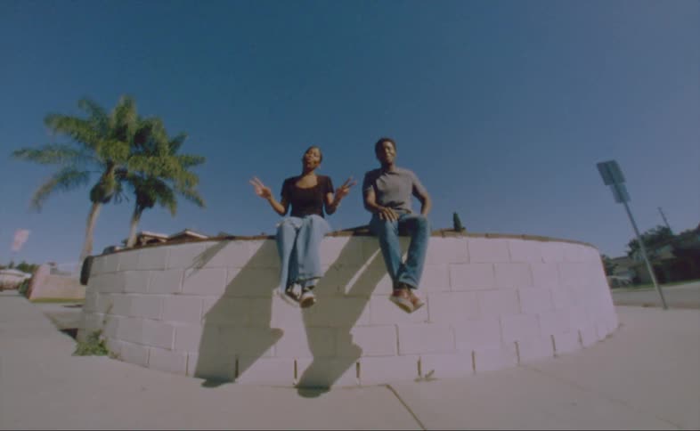 Man and woman are sitting on a ledge outdoors in the spring