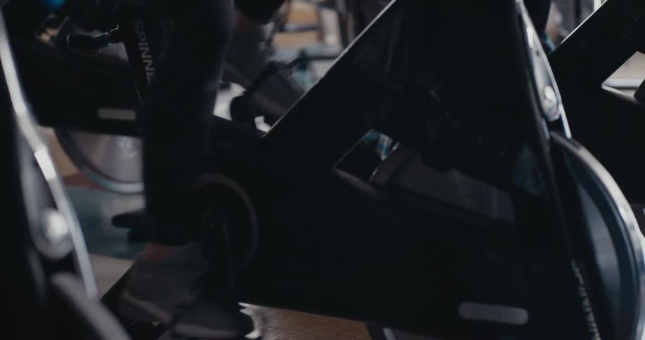 Legs pumping quickly on an exercise bike at the gym during a spin class
