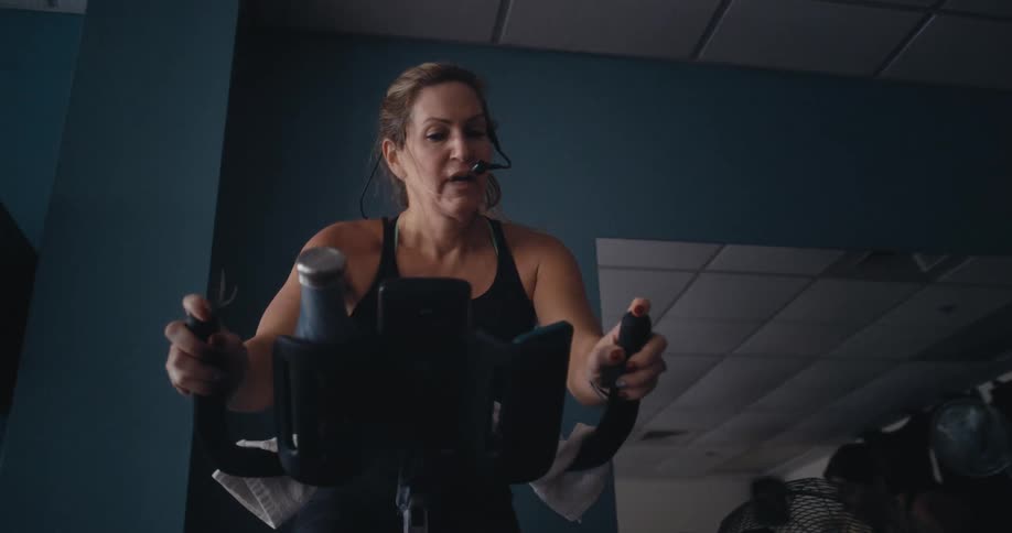 Women work out and ride exercise bikes in the gym