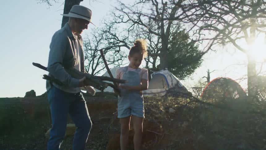 A man and child collect sticks for their camp