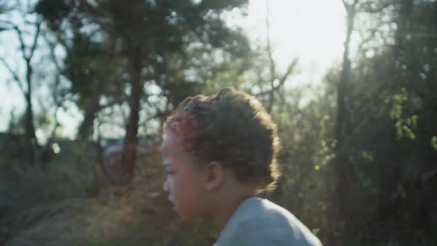 A child runs over to the man by the camp