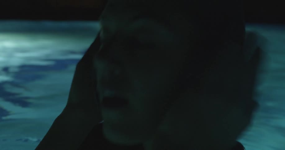 Woman in pool wiping water off of her face