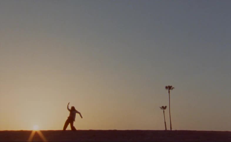 A person dances at sunrise