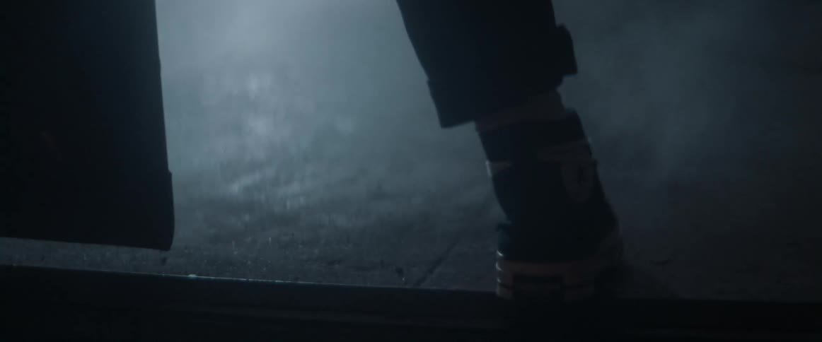 Person wearing high top sneakers walks through doorway