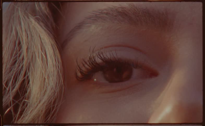 Blonde woman wearing mascara stares