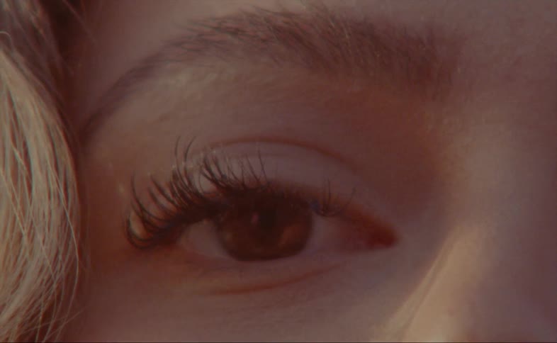 A woman wears false eyelashes to enhance her own