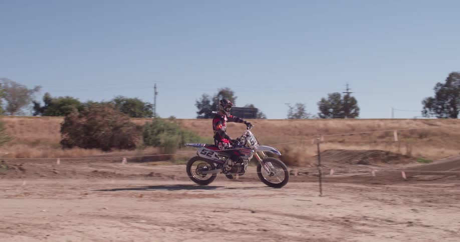 A dirt bike rides around a course