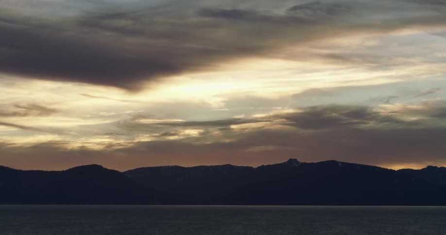 Clouds float over mountains at dusk