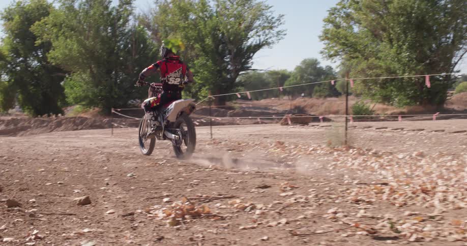 A person rides a dirt bike along a course during the day