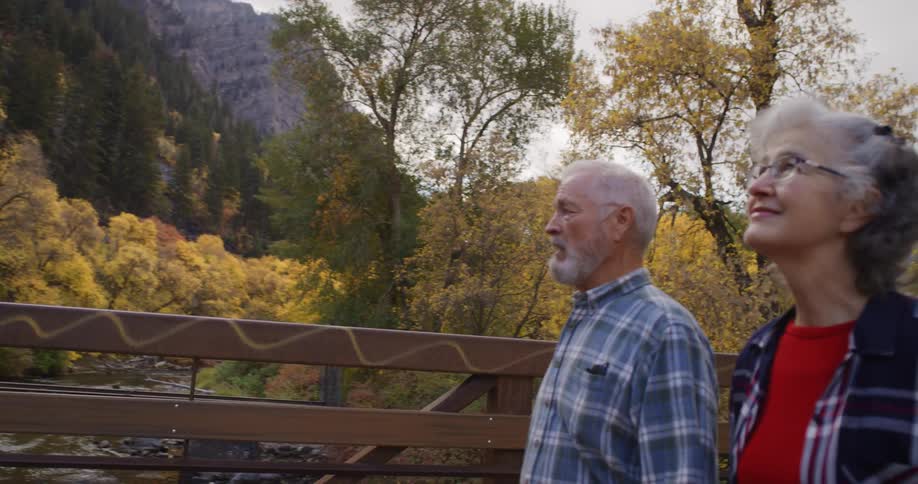 A man and woman hike over the bridge