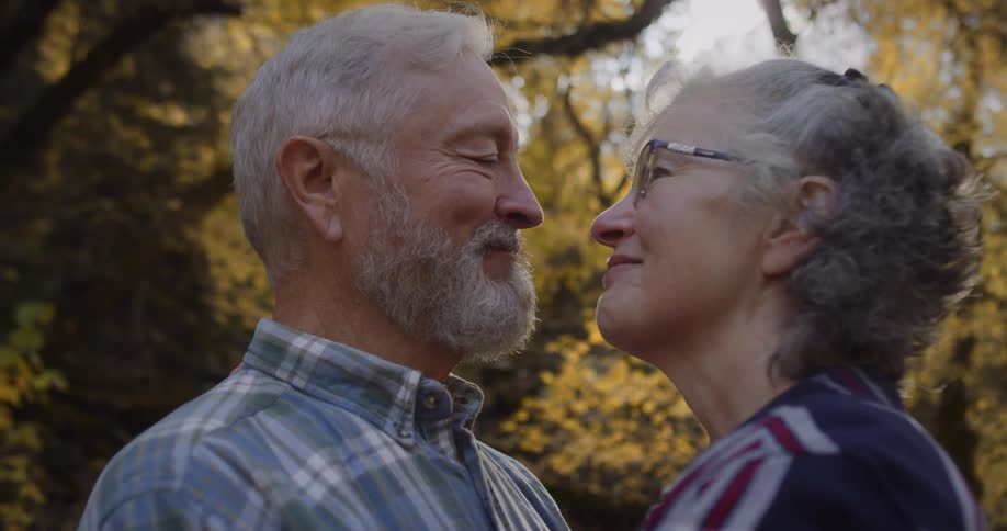 A couple talk close together in the forest