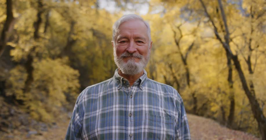 A man is smiling in the forest