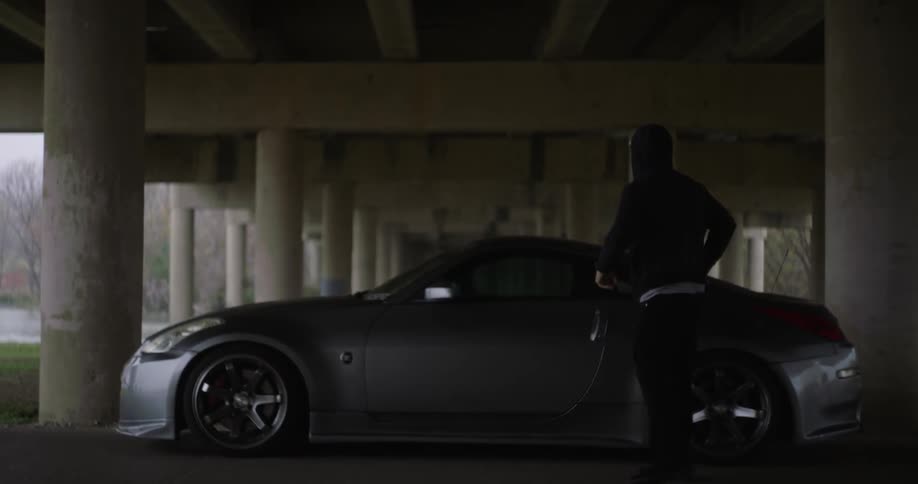 A person gets out of their gray car