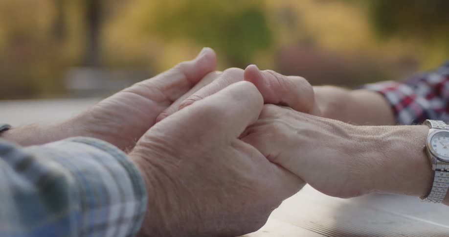 A close up of a man and woman holding hands