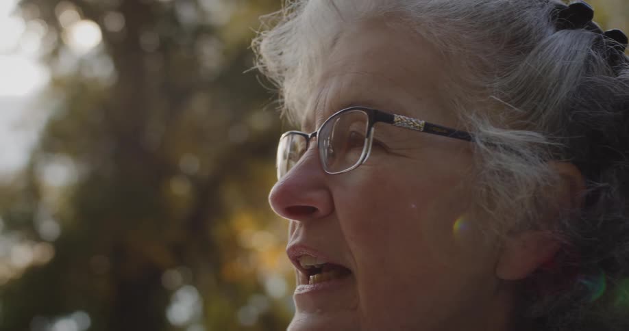 Close up of the face of an elderly woman talking outdoors
