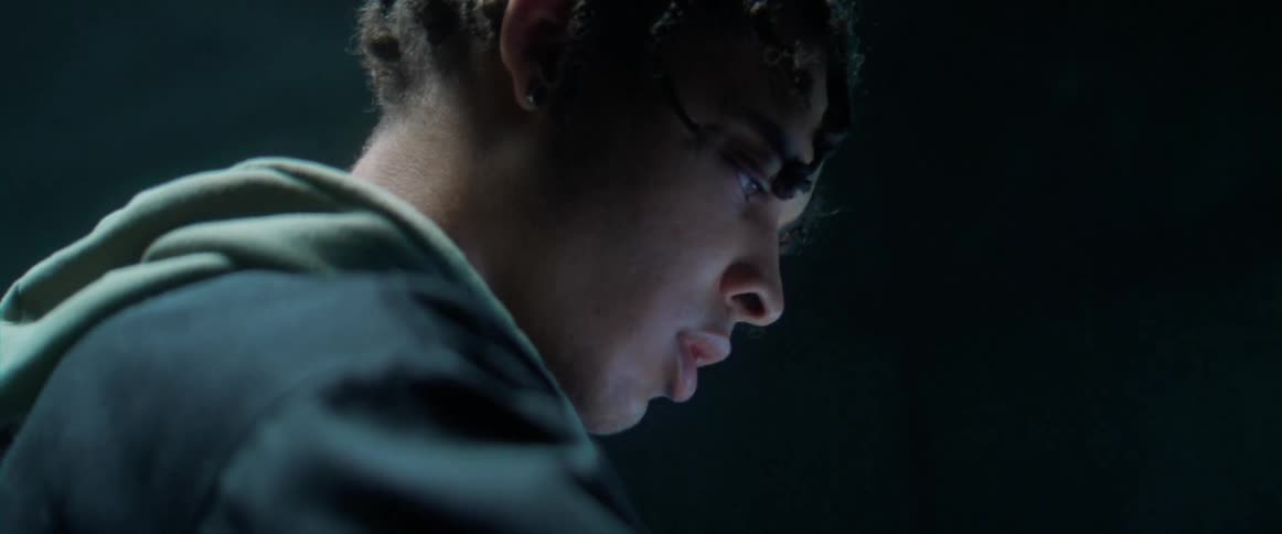 Young man using electronic equipment under strobing lights inside a dimly lit room