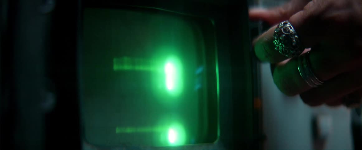 Young man using electronic equipment under strobing lights inside a dimly lit room