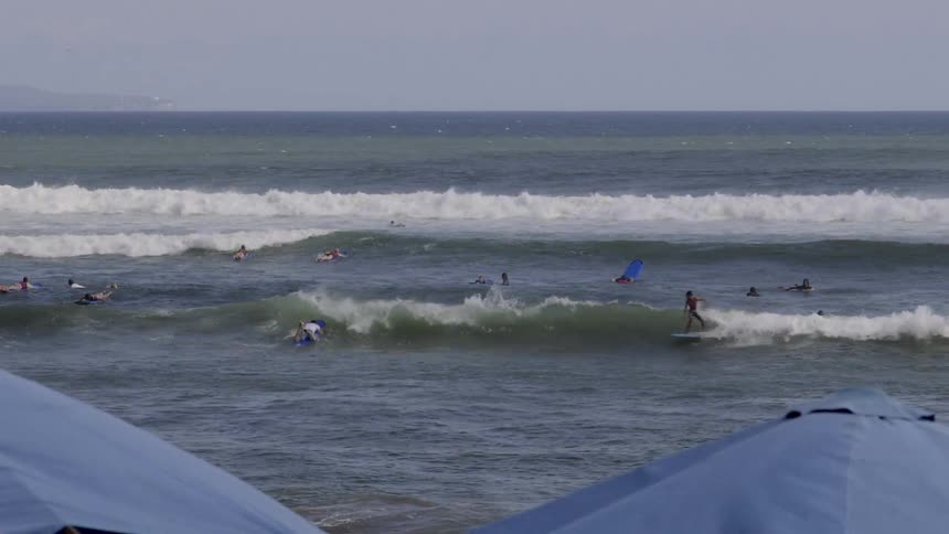 People float in the water on surfboards in the water