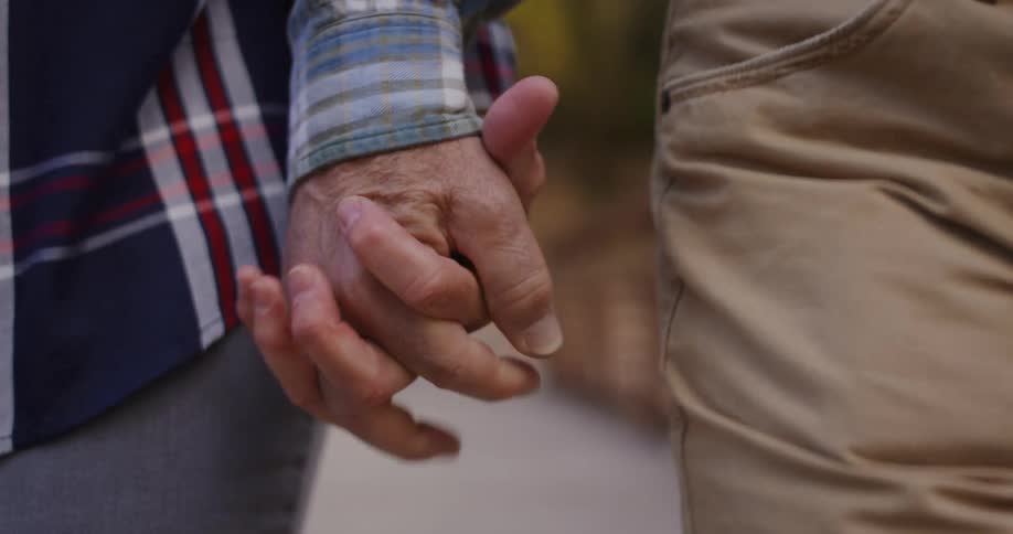 A man and woman holding hands walking outdoors