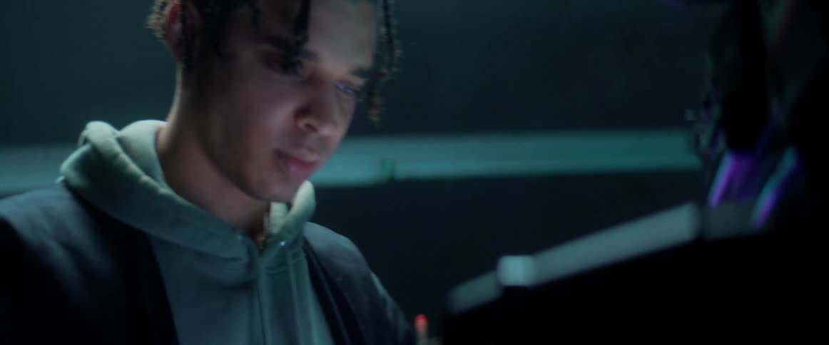 Young man using electronic equipment under strobing lights inside a dimly lit room