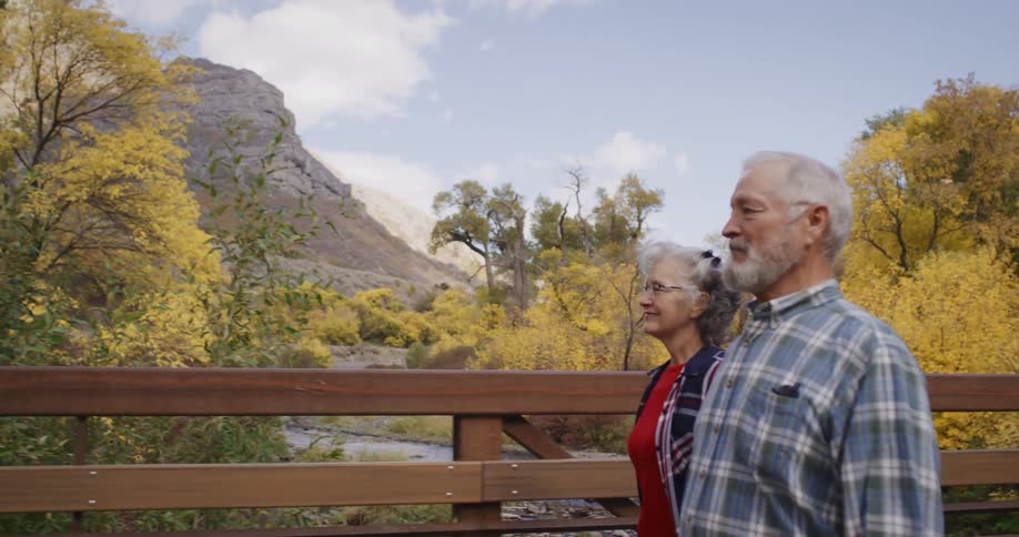 A man and woman hike over the bridge