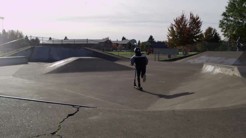 Kids skate in a park on a sunny day