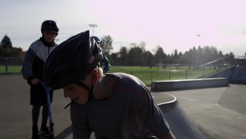 A kid does a jump in a skate park and is congratulated