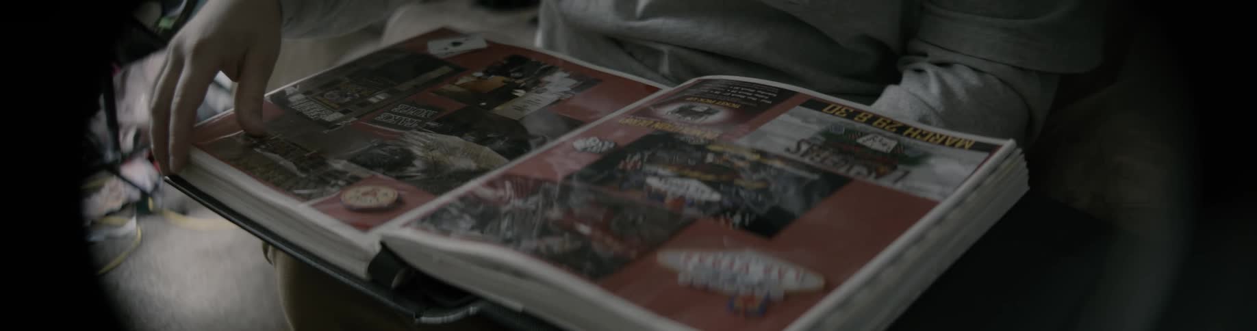 Someone has a photo book in their lap and they are turning the pages