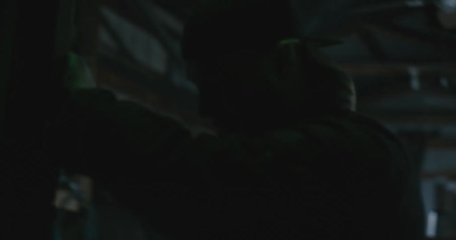 A man closes the door of a shop with a vehicle in it