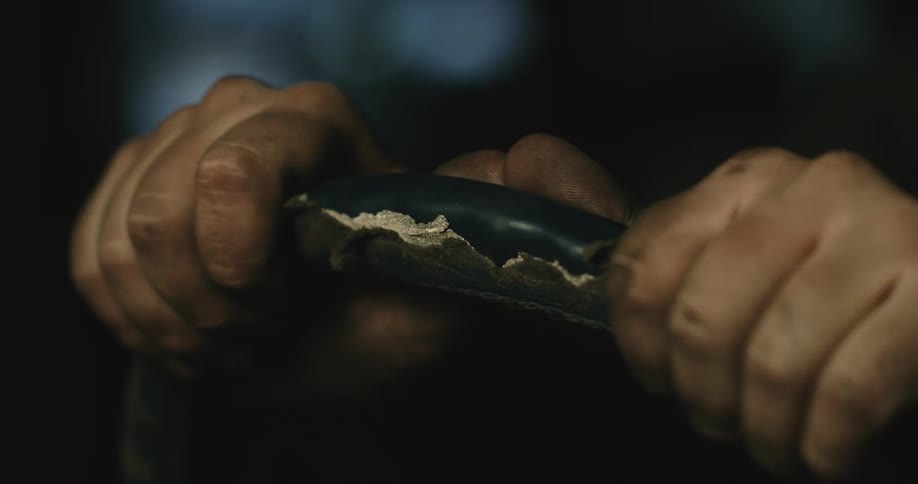 A man is gripping a steering wheel in a car at night