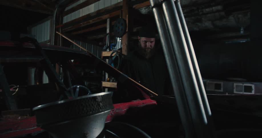 A man is inside a building and looks at a vehicle as he walks past it
