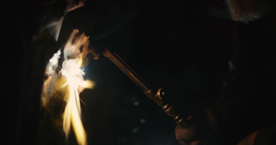 A man is welding a car wheel with a torch
